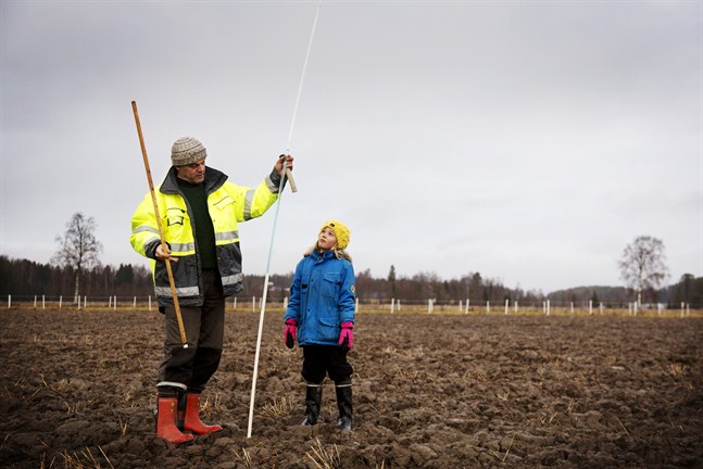 Christer Finne mäter tjälen en gång i månaden och rapporterar värdet till Miljöcentralen. Statistiken används för att göra översvämningsprognoser och konstruktionsberäkningar. Barnbarnet Ines Tuohimaa gör honom sällskap.