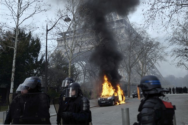 Ett polisfordon som stuckits i brand intill Eiffeltornet i Paris.