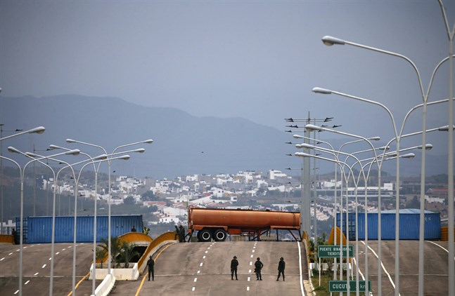 Containrar och lastbilar över en bro på gränsen mellan Colombia och Venezuela hindrar sedan i onsdags hjälpsändningar in i det krisdrabbade landet.