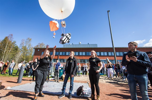 Michelle Berg, Emil Jåfs och Jenni Annala släpper iväg en CanSat-minisatellit. Den kan stiga upp till nitton kilometer innan ballongen spricker. Hittar eleverna boxen, som seglat ner med en fallskärm, får de data om väder och vind samt bilder. Till höger läraren André Forsman, en av tre kuggar inom Apolloprojektet i Petalax.