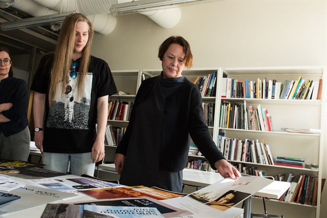 Affischer som gjorts till utställningarna på Galleri Gro har sparats. Här ser Ingela Bodbacka-Rak på den som sattes upp när den svenska fotografen Sofia Runarsdotter gästade galleriet. Bakom henne står Kevin Åkerlund och Annika Bergvik-Forsander.
