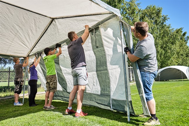 Talkoarbetarna Matias Nyby, Camilla Willberg, Juha-Pekka Suomela, Tony Pellfolk och Jouko Oikarainen reser ett tält inför Wasa football cup 2019.