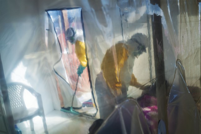 Hälsoarbetare i skyddskläder tillsammans med en isolerad ebolasmittad person i Beni i Kongo-Kinshasa, 13 juli 2019.