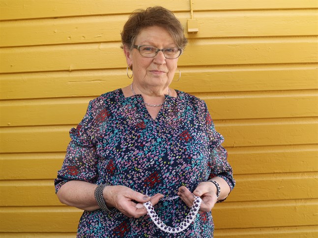 Barbro Lindgren utanför Hantverkarboden i Jakobstad. I handen håller hon en av de många vikingakedjor som hon tillverkat.