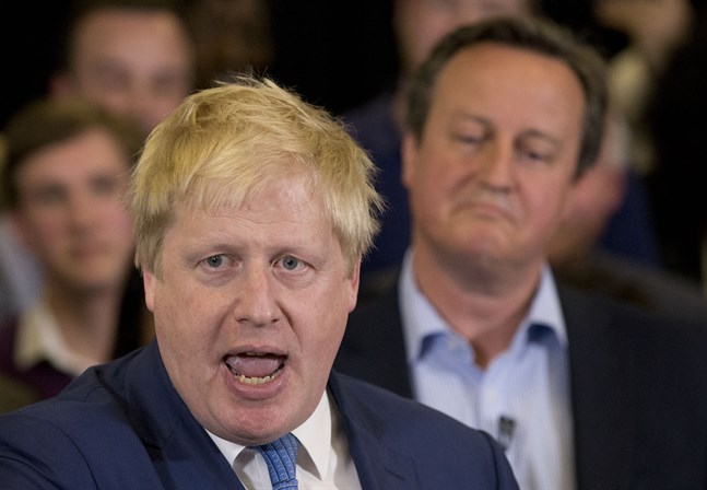 Storbritanniens premiärminister Boris Johnson med tidigare premiärministern David Cameron i bakgrunden.