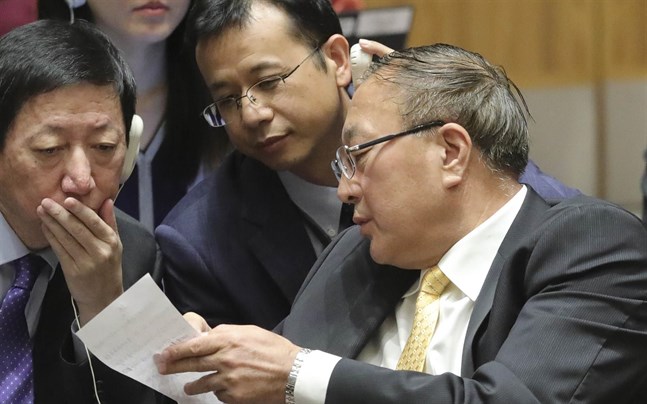 Kinas FN-ambassadör Zhang Jun (till höger) överlägger med sina medarbetare under säkerhetsrådets möte om Syrien.