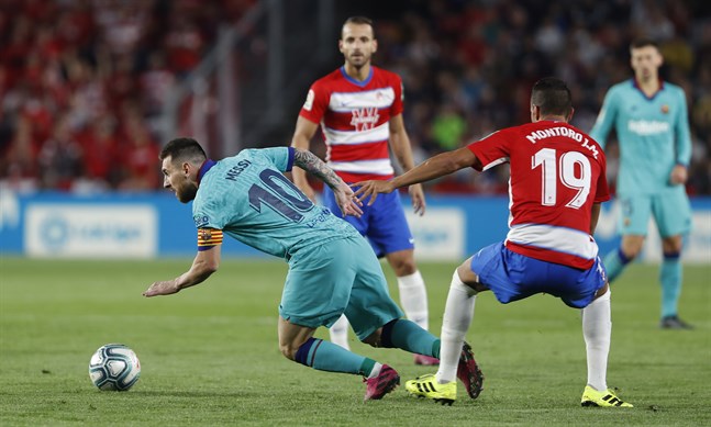 På fall. Barcelonas Leo Messi står på öronen i en närkamp med Granadas Yangel Herrera.
