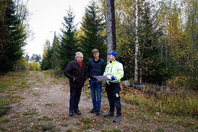 Styrelseordförande Hans-Erik Storlund, ekonomiansvarige Johan Nordmyr och vd Staffan Julin studerar planritningen för Malmbyn. De står precis vid tomtens början.