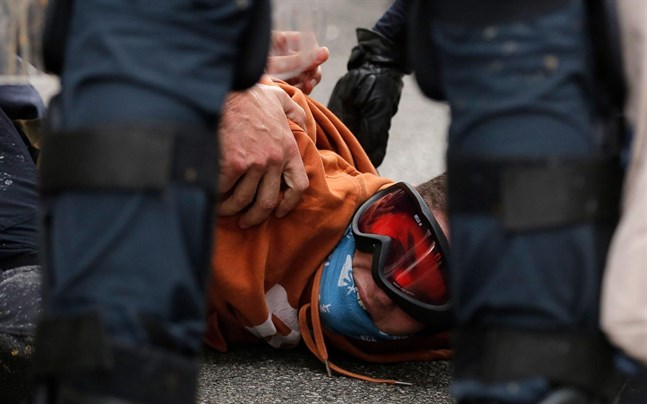 Polisen griper en ung demonstrant.