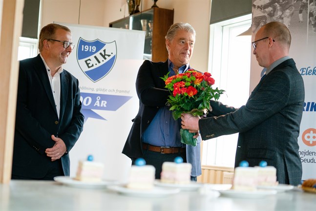 Pedersöre kommun tillhörde dem som uppvaktade Esse IK under jubileumsdagen. Kommunstyrelsens ordförande Greger Forsblom och idrottssekreterare Leif Harjulin överräcker blommor till klubbens ordförande Glenn Sundkvist.