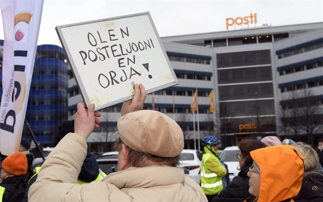 "Jag är postiljon, inte slav" står det på plakatet. Demonstrationen fick Posten att ändra sina tisdagsplaner i Helsingfors.