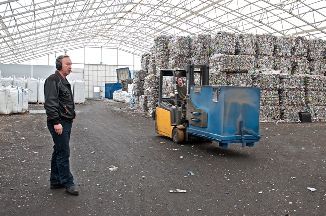 Miljontals tomma plastflaskor bakom Jari Korkiakangas i lagret i Toholampi. Returflaskorna är redo för krossning, nedsmältning och återanvändning.