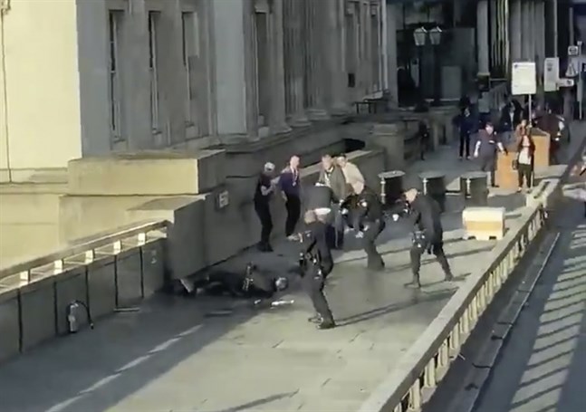 Polisen omringar en misstänkt gärningsman efter knivattacken vid London Bridge. Bilden är en skärmdump från ett videoklipp.
