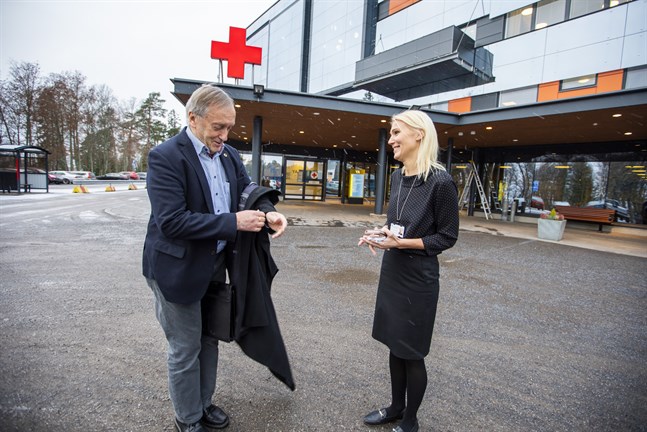 Hans Frantz tar av sig kappan för att låta ut den till Marina Kinnunen under fotograferingen utanför akuten i Vasa.