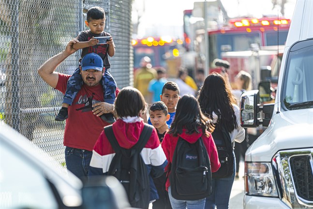 Barn evakueras efter att de och deras skola i stadsdelen Cudahy i Los Angeles fått flygbränsle släppt på sig.