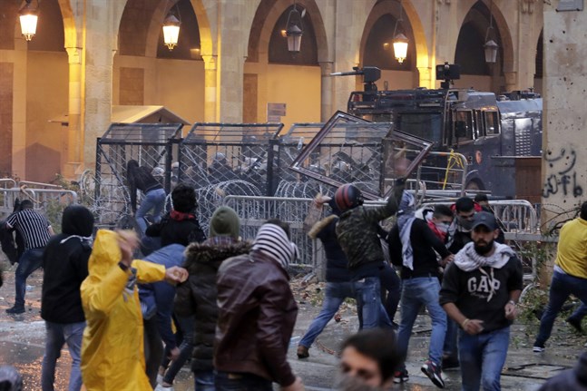 Demonstranter drabbar samman med kravallpolis vid en av vägarna som leder fram till Libanons parlament i Beirut.