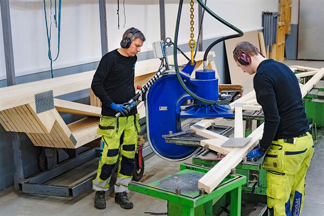 Krister Östman och Ronnie Asplund jobbar med att konstuera takstolar. Spikplåtarna fästs i trät med en fyrtio tons press.