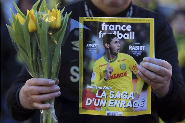 En Nantes-supporter med en fotbollstidning vars omslag pryds av Emilano Sala. Arkivbild.