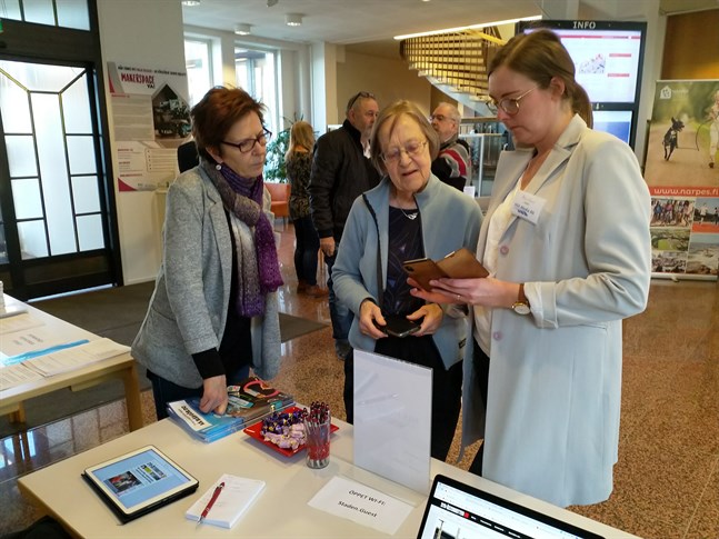 Även Sydin är med på digimässan i Närpes stadshus i dag. Margit Ruosteluoma från kundtjänsten och Malin Bylund från redaktionen ger här Marianne Storgård tips om Sydins digitala innehåll. I bakgrunden ser vi Olav Nordberg samtala med Rolf Hellman.
