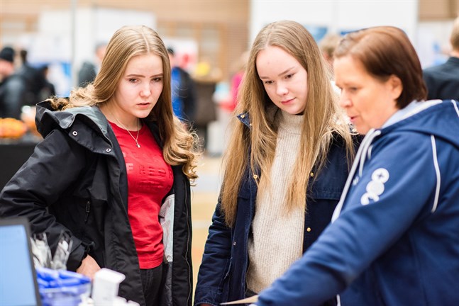 Päivi Tikka, chef för vårdhemmet Attendo Majakka Hakalahti i Karleby, visar närvårdarstuderandena Jenna Vähätiitto och Matilda Enlund vilka sommarjobb man erbjuder.
