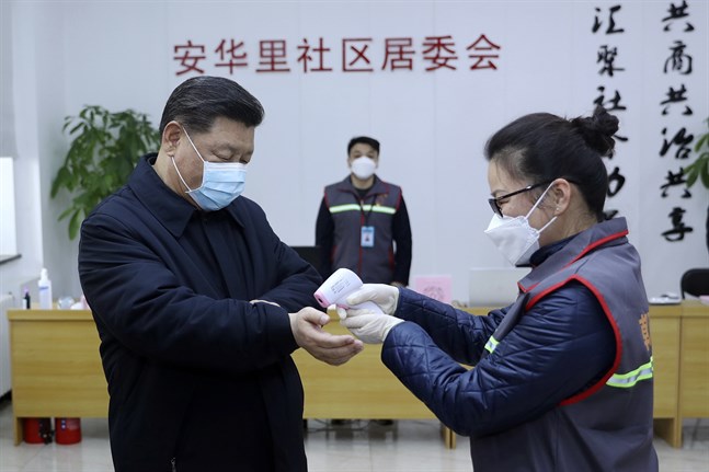 Kinas president Xi Jinping får temperaturen kontrollerad under ett besök på en vårdinrättning i Peking. Bild distribuerad av Kinas statliga nyhetsbyrå Xinhua 10 februari.