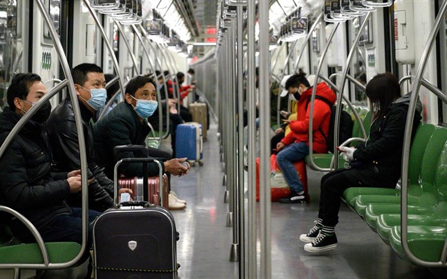 Resenärer använder ansiktsmasker på metron i Shanghai.