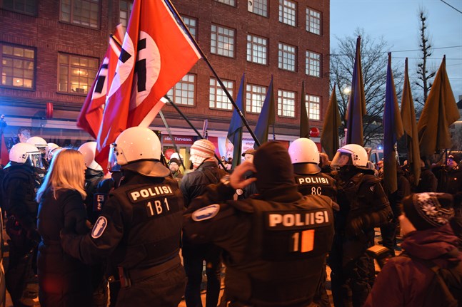 Sex personer åtalas för hets mot folkgrupp efter att de burit på nazistflaggor i ett demonstrationståg på självständighetsdagen 2018.