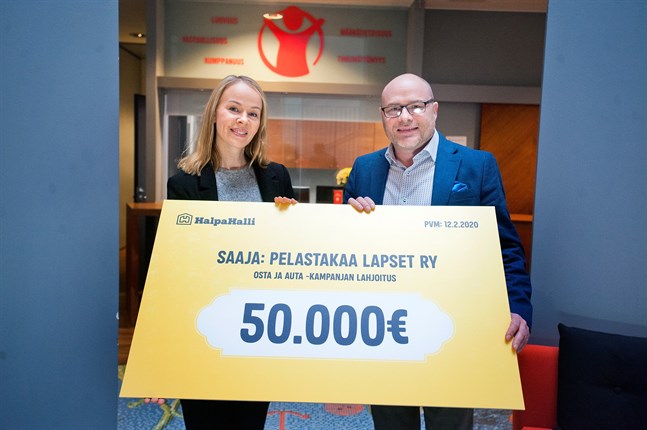 Heli Le tar emot donationen till Rädda Barnen från Halpa-Hallis marknadschef Juha Hakala.