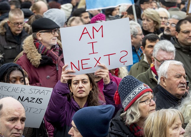 En kvinna håller upp en skylt med texten "Står jag på tur?" under en demonstration i Hanau lördagen efter det misstänkta terrordådet.