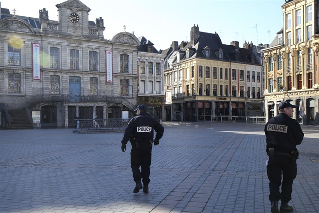 Polis patrullerar ett tomt torg i Lille i norra Frankrike.