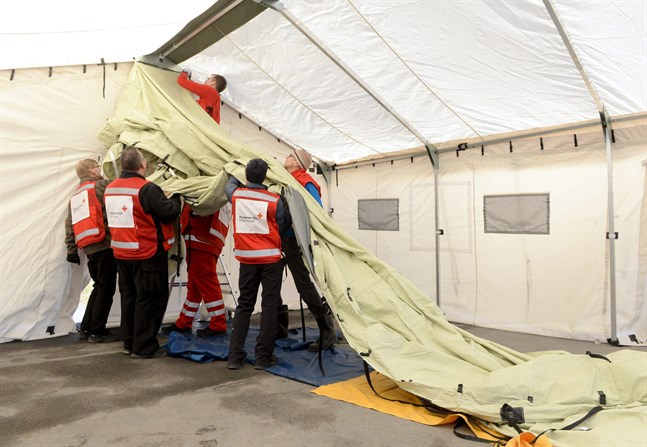 Finlands Röda Kors frivilliga reser en triage-enhet utanför Hyvinge sjukhus.