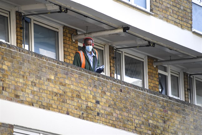 En brevbärare delar ut post i London.