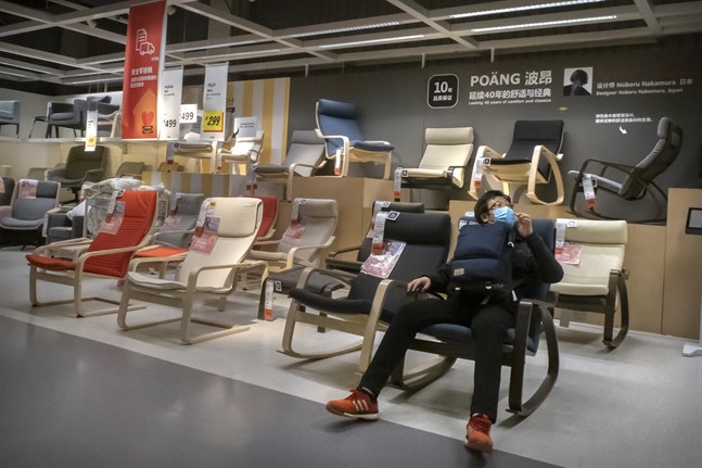 En man med munskydd provar en stol på Ikea i Peking. Arkivbild.