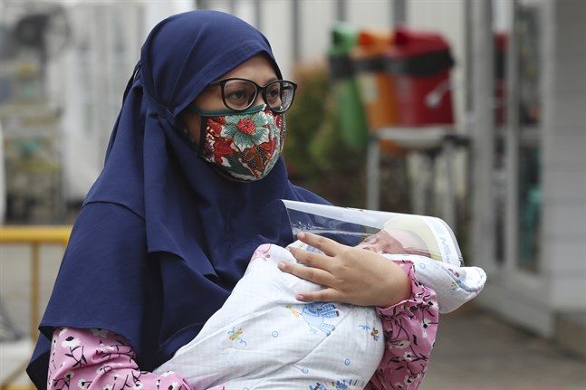 En kvinna med sitt barn på ett sjukhus i Indonesiens huvudstad Jakarta under coronapandemin. Arkivbild.