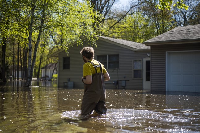 En boende i Midland, Michigan, vadar genom vattenmassorna för att nå sitt hem.