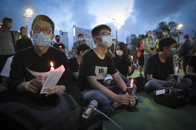 Den framträdande demokratiaktivisten Joshua Wong (mitten) är en av de som samlats för ljusmanifestationen för massakern på Himmelska fridens torg.