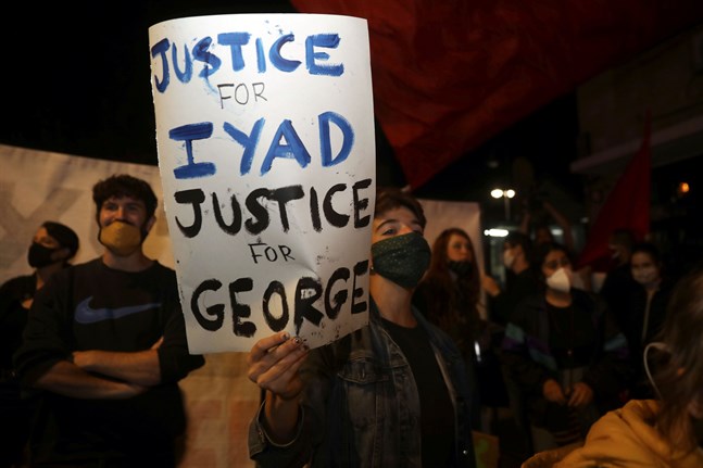 Demonstranter i Jerusalems gamla stadskärna håller upp plakat som kräver rättvisa för Iyad Halak och George Floyd. Bilden är från den 30 maj, samma dag som Halak sköts ihjäl.