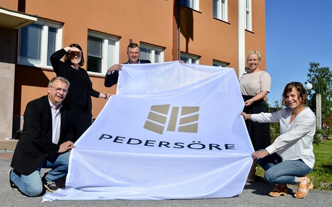 Greger Forsblom, Johanna Öst Häggblom, Stefan Svenfors, Johanna Holmäng och Ida-Maria Wikström visar upp Pedersöres nya logo utanför kommunhuset.