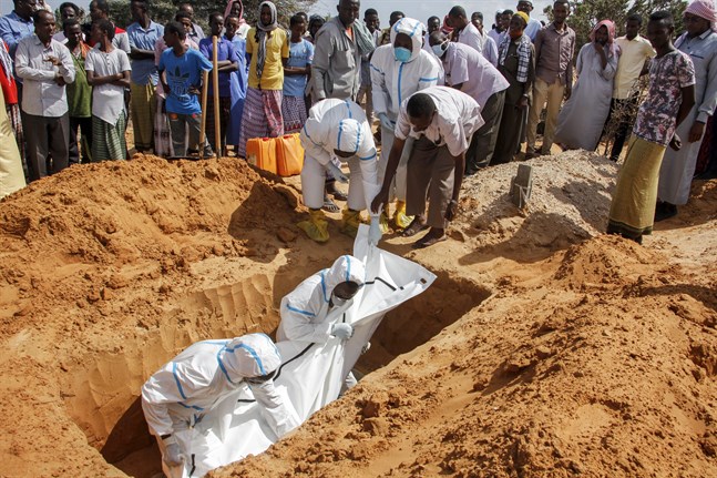 Vårdpersonal i skyddsutrustning vid en begravning av en man som dött i covid-19 på en kyrkogård i Somalias huvudstad Mogadishu. Arkivbild.