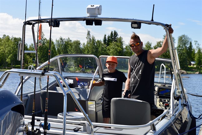 Wiliam och Dennis Kronholm visar upp sin båt. Sonen Wiliam är mycket intresserad av fiske.