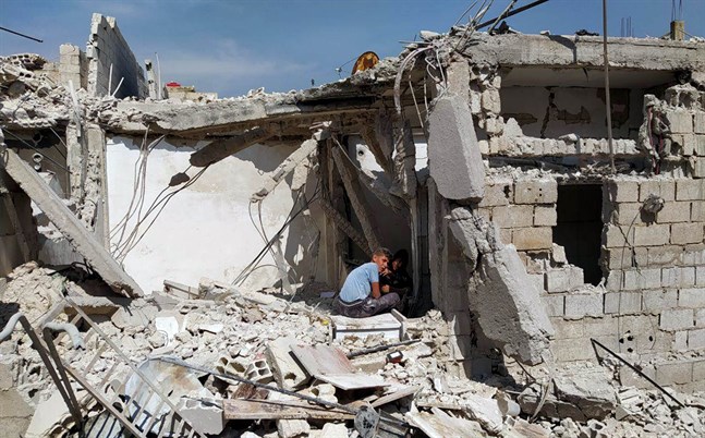 Pojkar leker i en ruin i en förort till det krigshärjade Syriens huvudstad Damaskus.