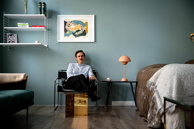 Matias Mäkynen i småbarnsfamiljens sparsamt inredda rum som fungerar som sovrum och vardagsrum samtidigt.