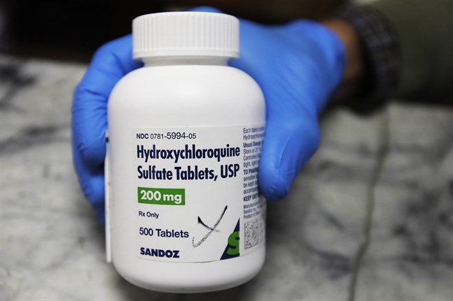 En apotekare håller en flaska hydroxyklorokintabletter. Arkivbild.