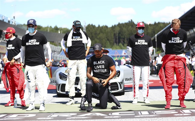 Lewis Hamilton knäböjer inför F1-premiären i Österrike.
