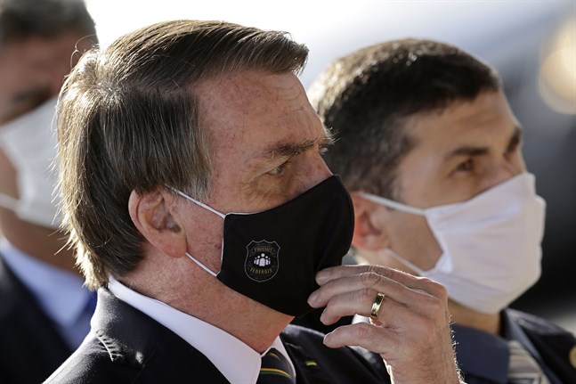 Brasiliens president Jair Bolsonaro visar symptom för covid-19. Arkivbild.