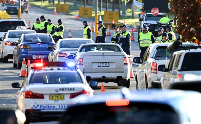 Polis vid gränsen mellan delstaterna Victoria och New South Wales i Australien. Victoria och dess huvudstad Melbourne har återgått till strängare restriktioner för att motverka spridningen av coronaviruset. Bland annat stängdes gränsen mellan delstaterna häromdagen.