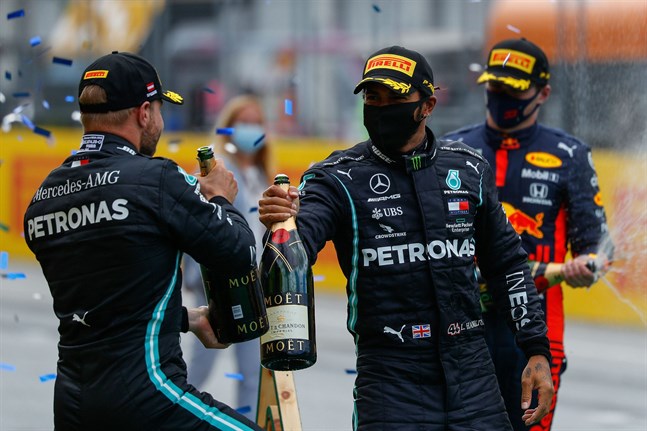 Valtteri Bottas gratulerar stallkamraten Lewis Hamilton till segern. I bakgrunden Max Verstappen.