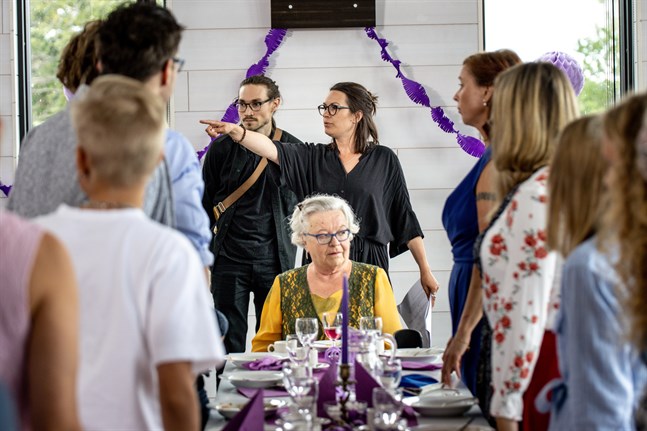 Fotografen Erik Åhman och regissören Annika Wilhelmsdotter Åman diskuterar en scen. Vid bordsändan sitter Barbro Värnman som spelar Signe.
