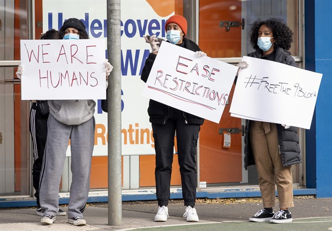 Kvinnor protesterar mot de nya virusrestriktionerna vid ett drabbat bostadskomplex i Melbourne den 6 juli.