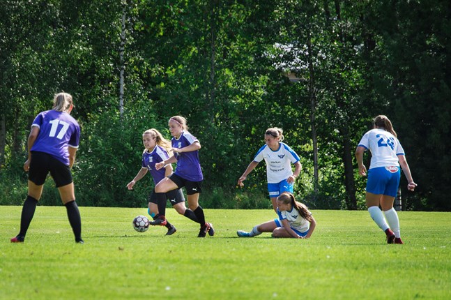 Rebecka Holmbäck driver fram med bollen för FC United, medan Lovisa Vikström gör sig beredd att göra en djupledslöpning inför Vanessa Haavisto (17).